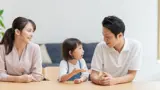  A couple speaking to their young child at the dining table. 