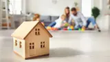 Small wooden house with a family playing in the background. 